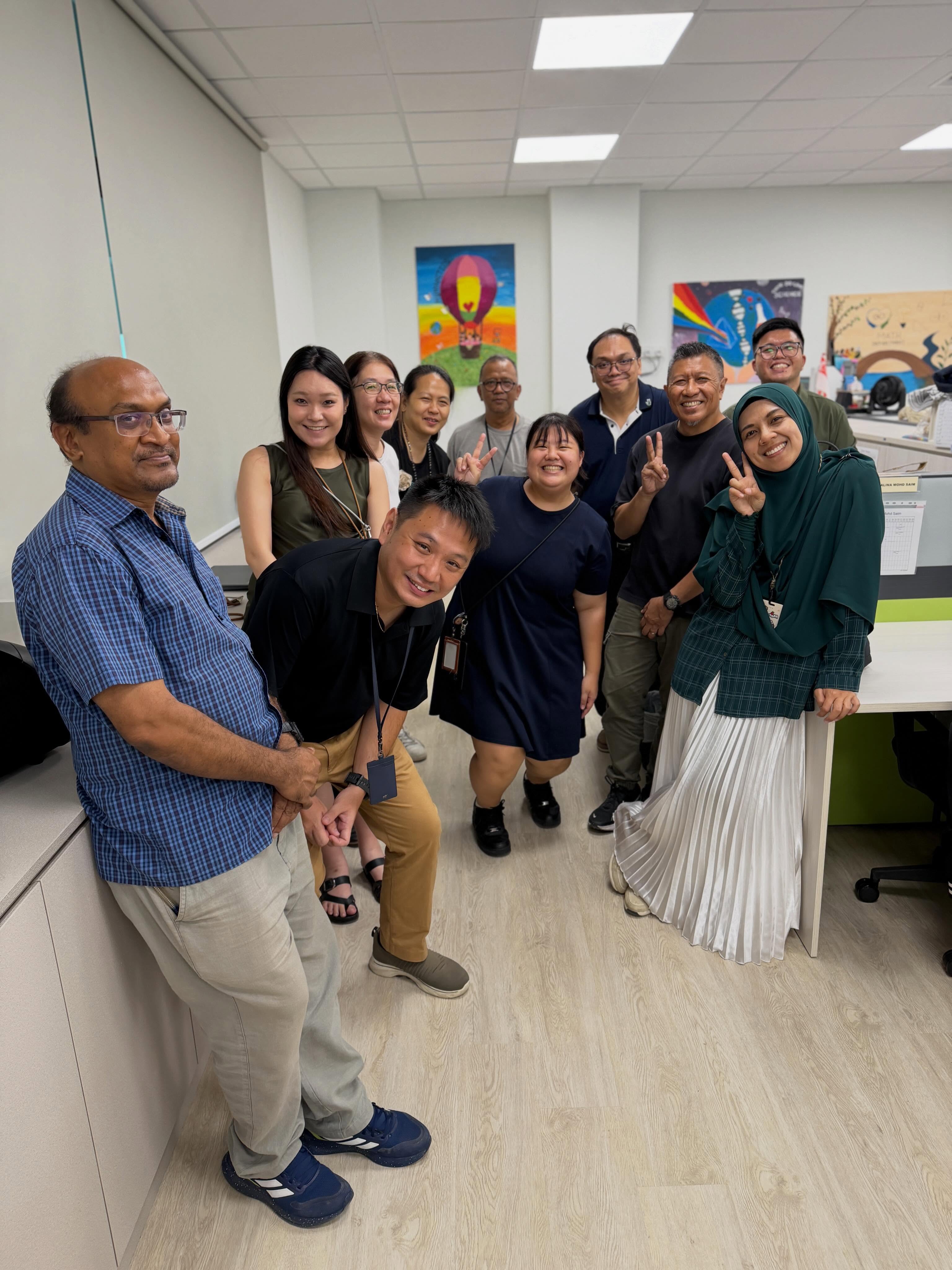 A group of staff from the Aesthetic and Craft & Technology Department posing together in the newly renovated CTSS staffroom.