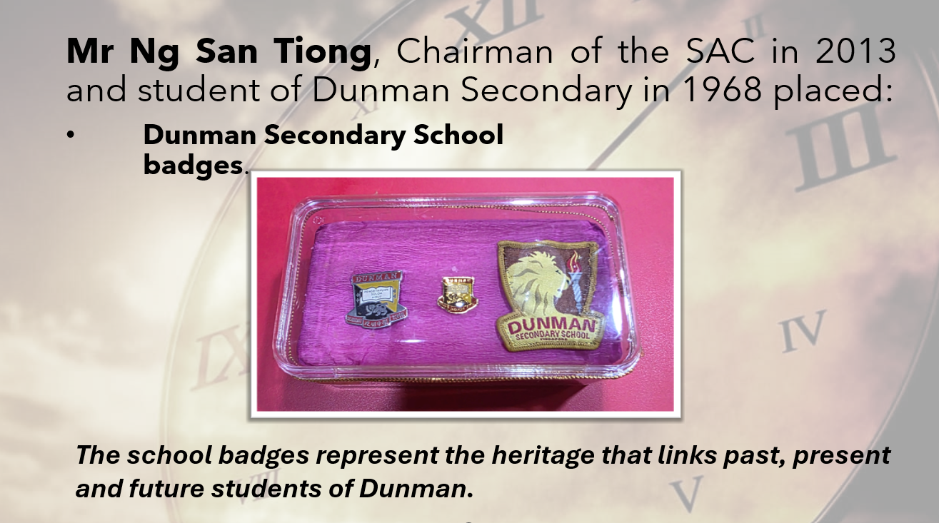 Three Dunman Secondary School badges displayed in a clear box on pink fabric, including two pins and one embroidered patch.