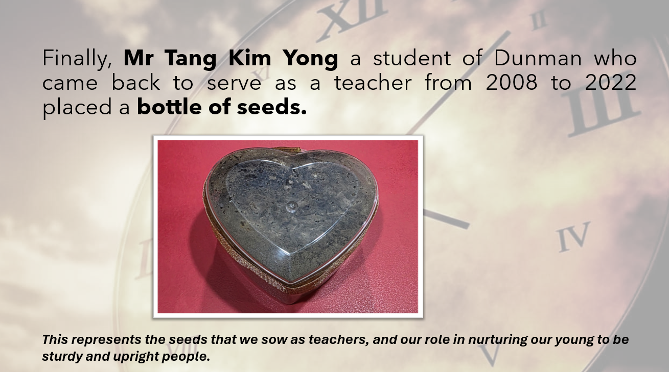 A heart-shaped stone or metal container on a red surface, with text about a teacher placing a bottle of seeds.