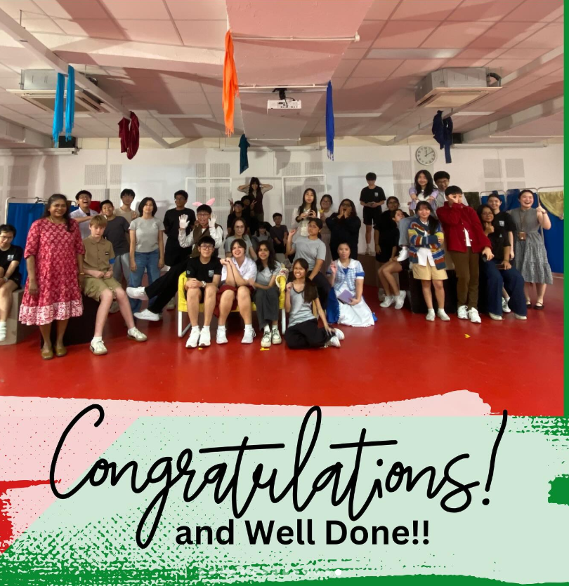 A large group of students posing in a hall with colorful flags, text reads Congratulations and Well Done.