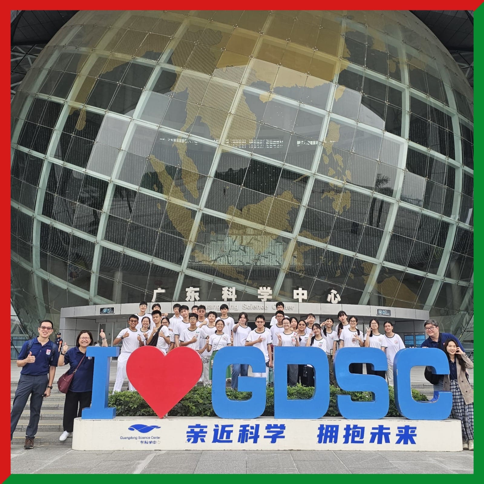 Group of students posing in front of the Guangdong Science Center globe building behind an "I Love GDSC" sign.