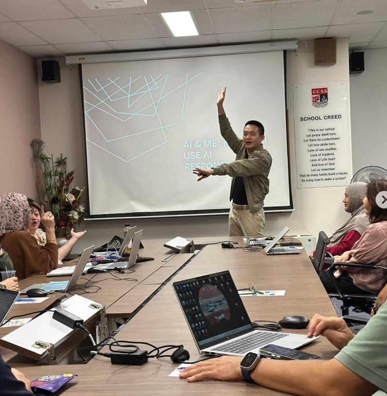 A man presents an AI topic on a projector screen to seated participants with laptops at a conference table.