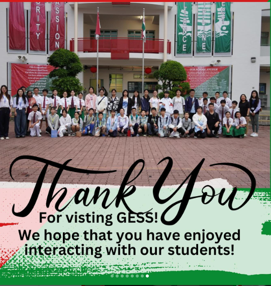Large group of students posing outside a school building with a Thank You for visiting GESS message below.