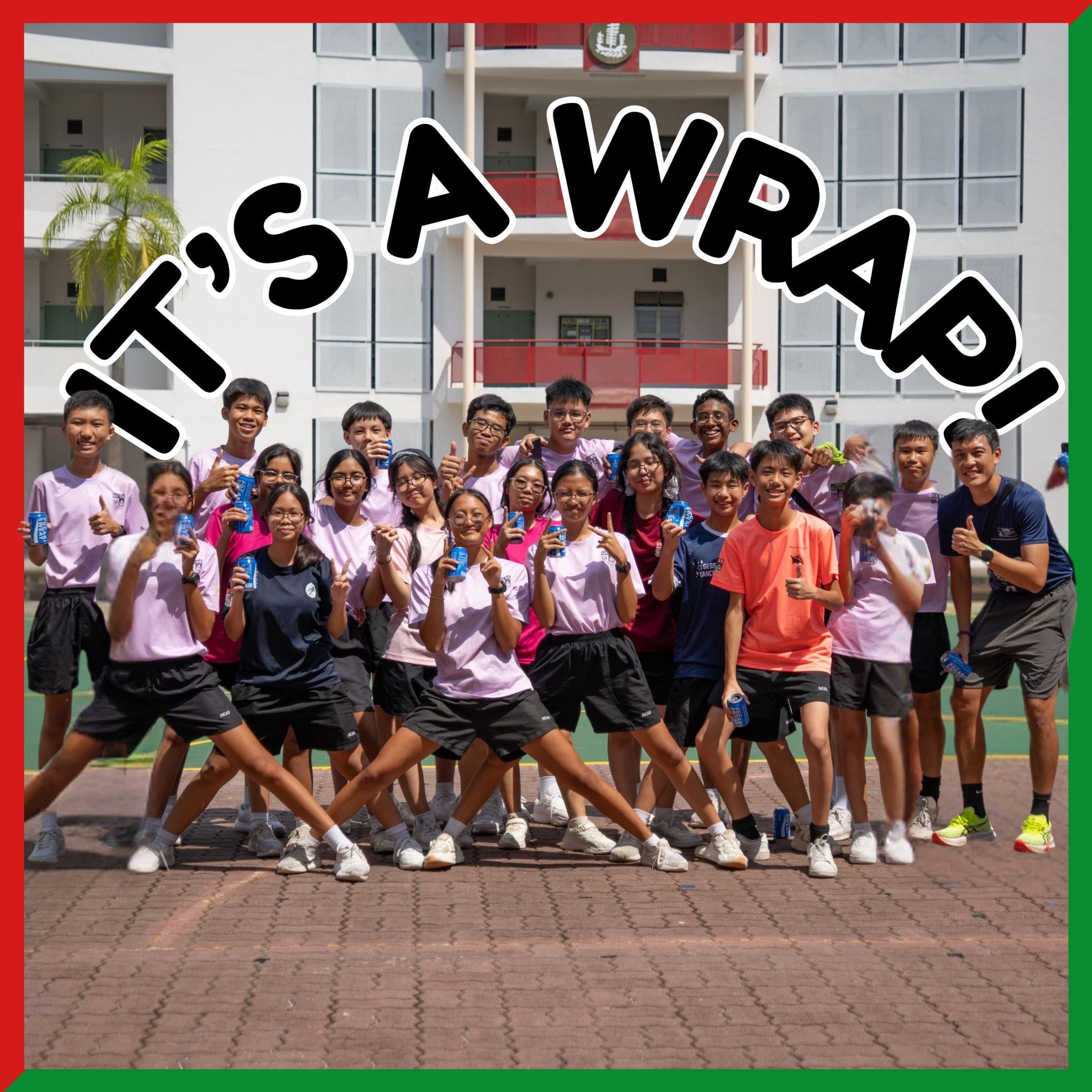 Group of students in pink shirts posing outdoors at a school with text reading IT'S A WRAP!