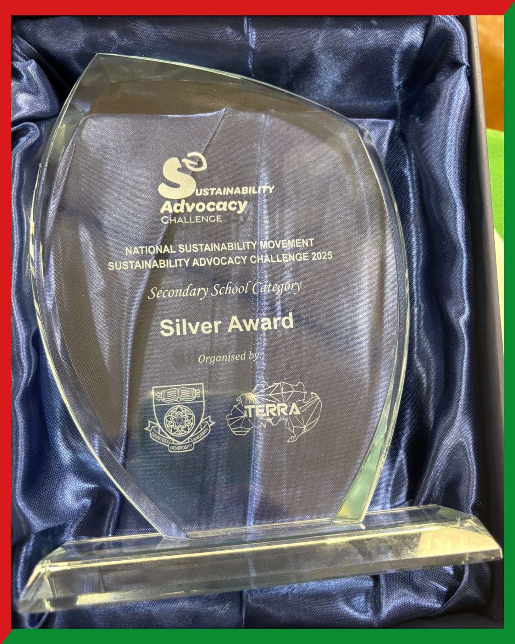 Glass trophy engraved with Silver Award for Secondary School Category, Sustainability Advocacy Challenge 2025, in a blue satin box.