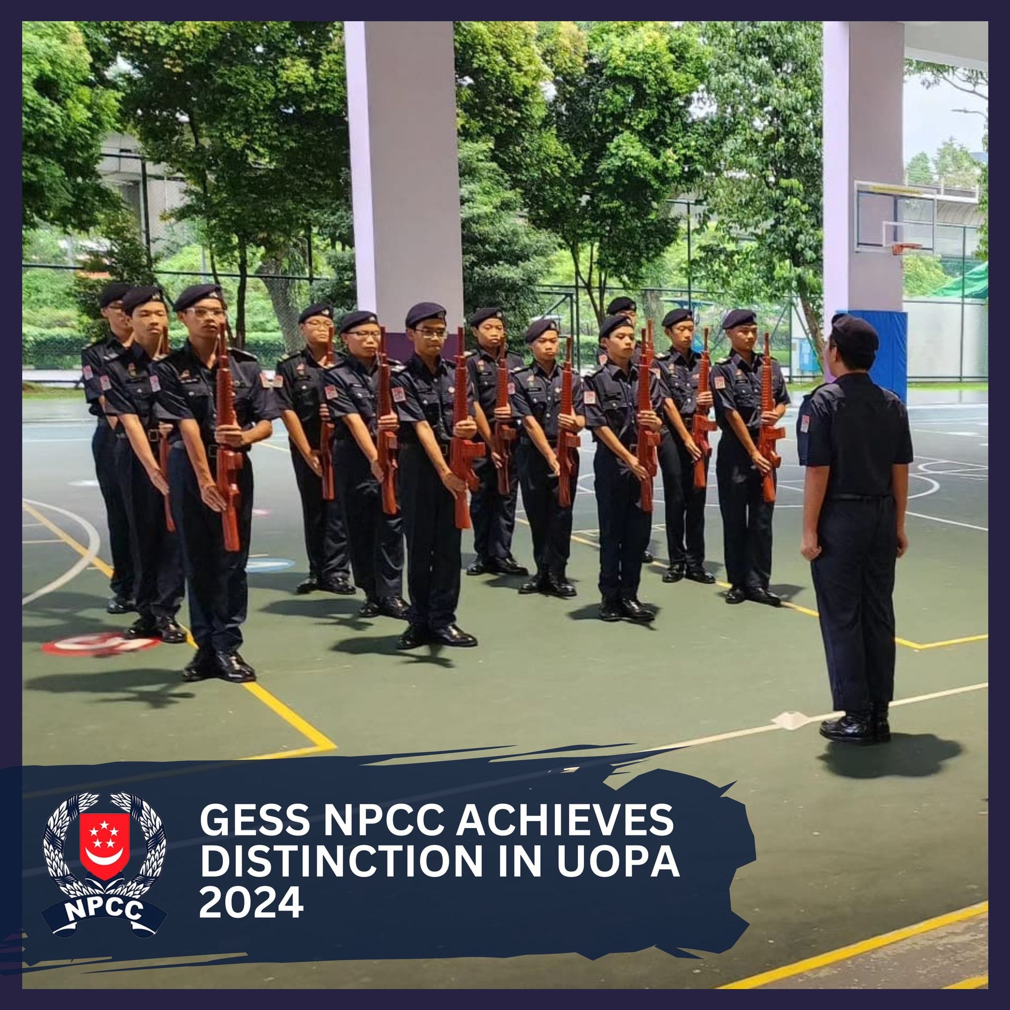NPCC cadets in dark uniforms holding wooden rifles stand at attention on a court, facing an officer.