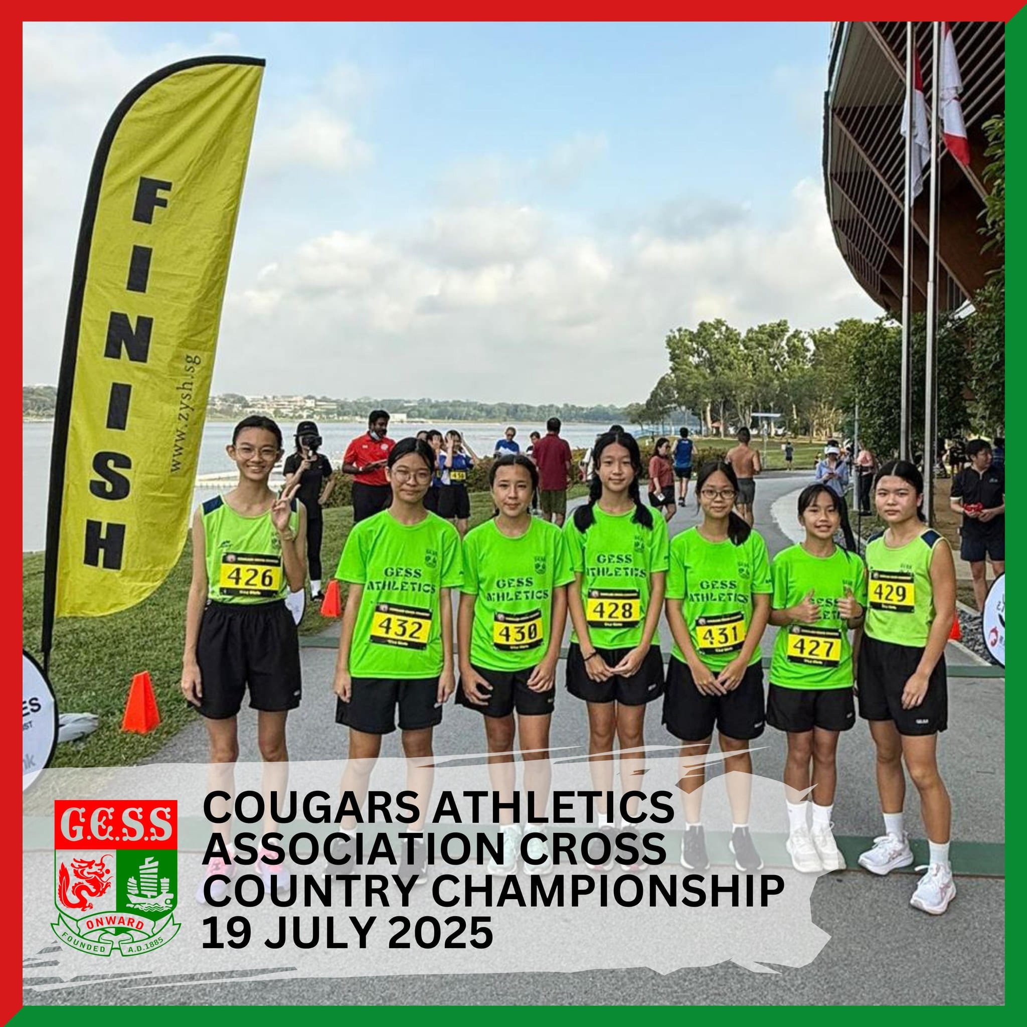 Seven girls in green GESS Athletics race bibs pose near a yellow Finish banner at a cross country event on 19 July 2025.