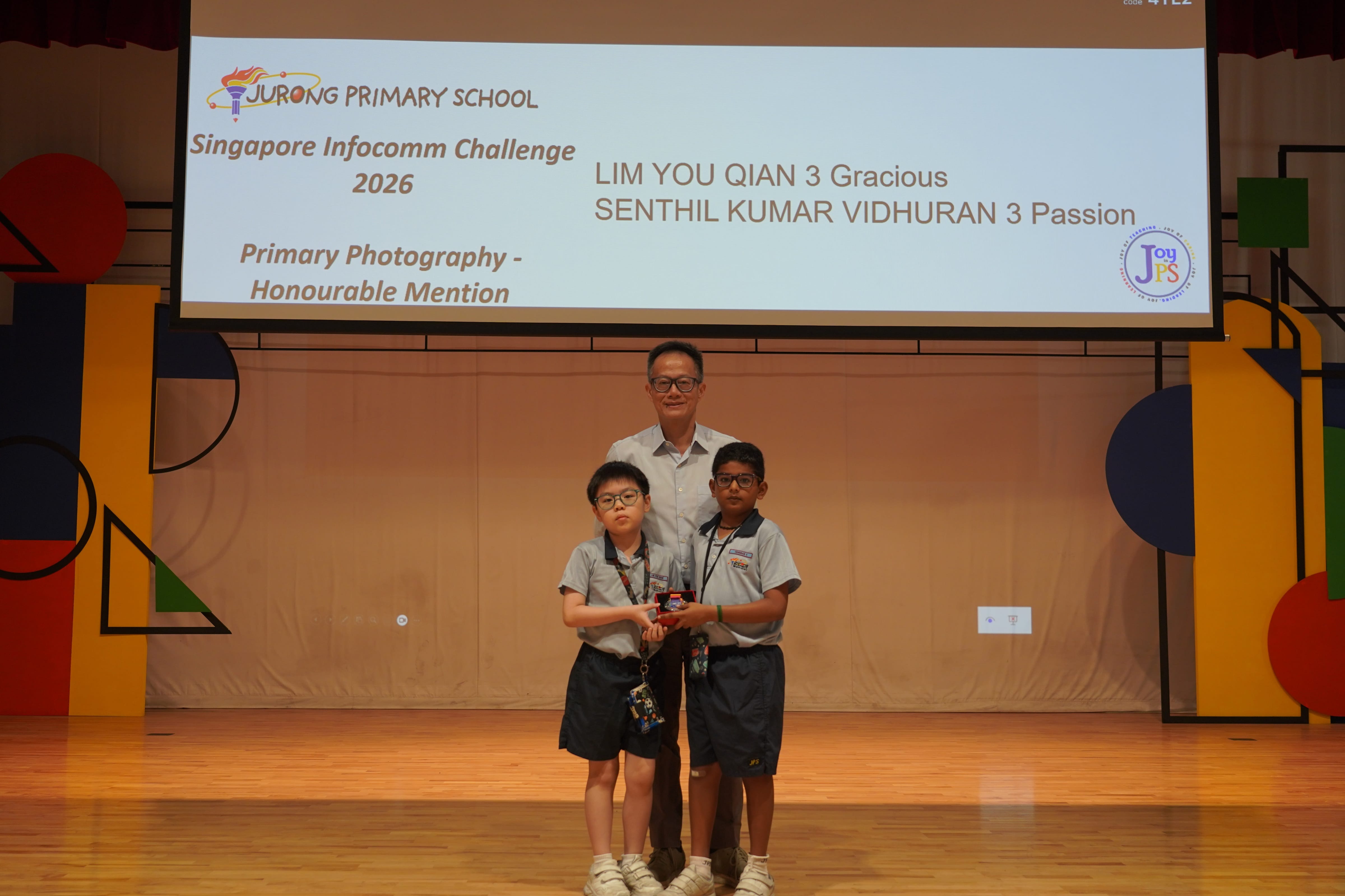 Two boys with a trophy and Vice-Principal, Singapore Infocomm Challenge 2026 Photography Honourable Mention.
