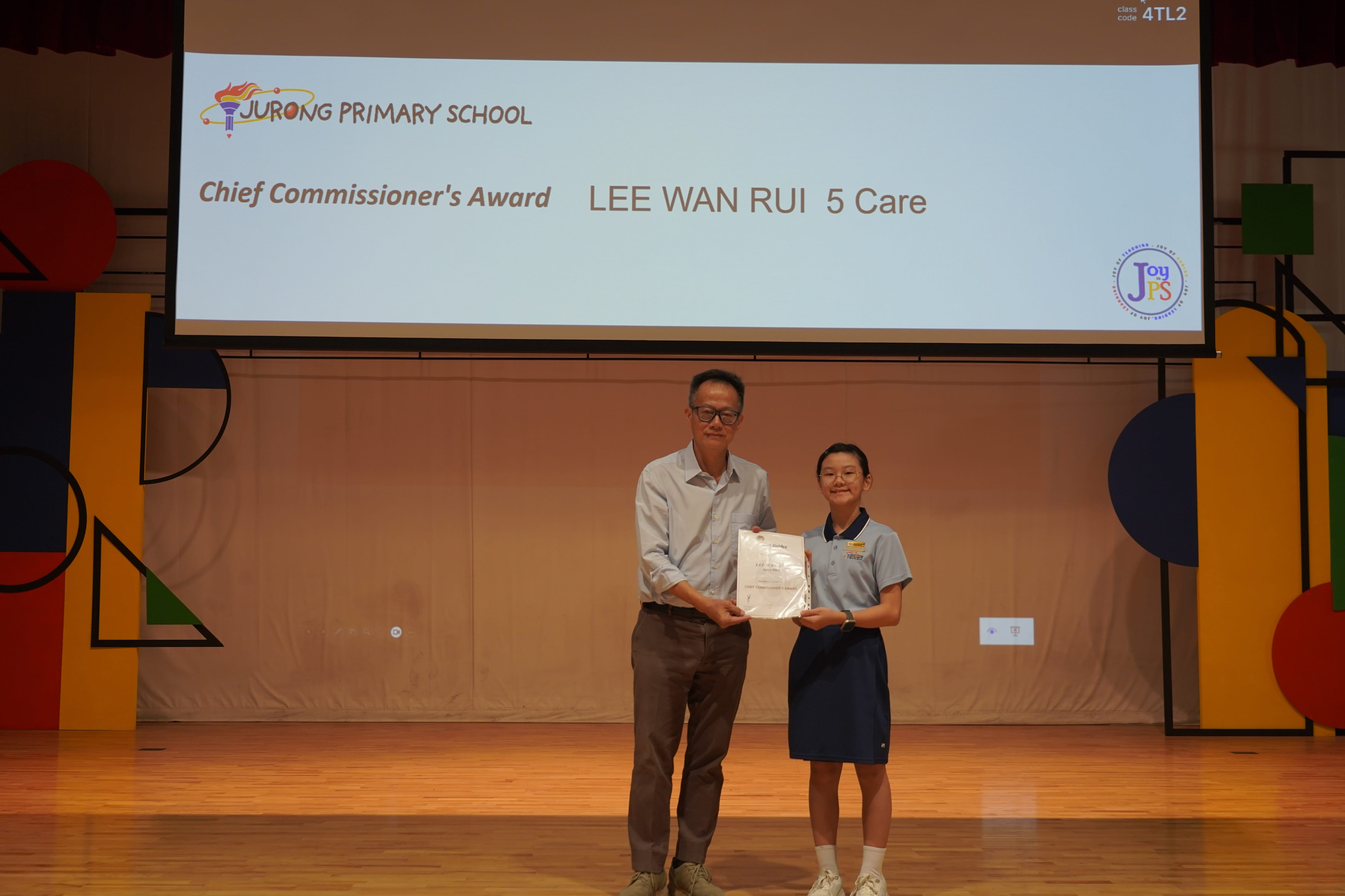 A girl receives a certificate from Vice-Principal for the Chief Commissioner's Award.