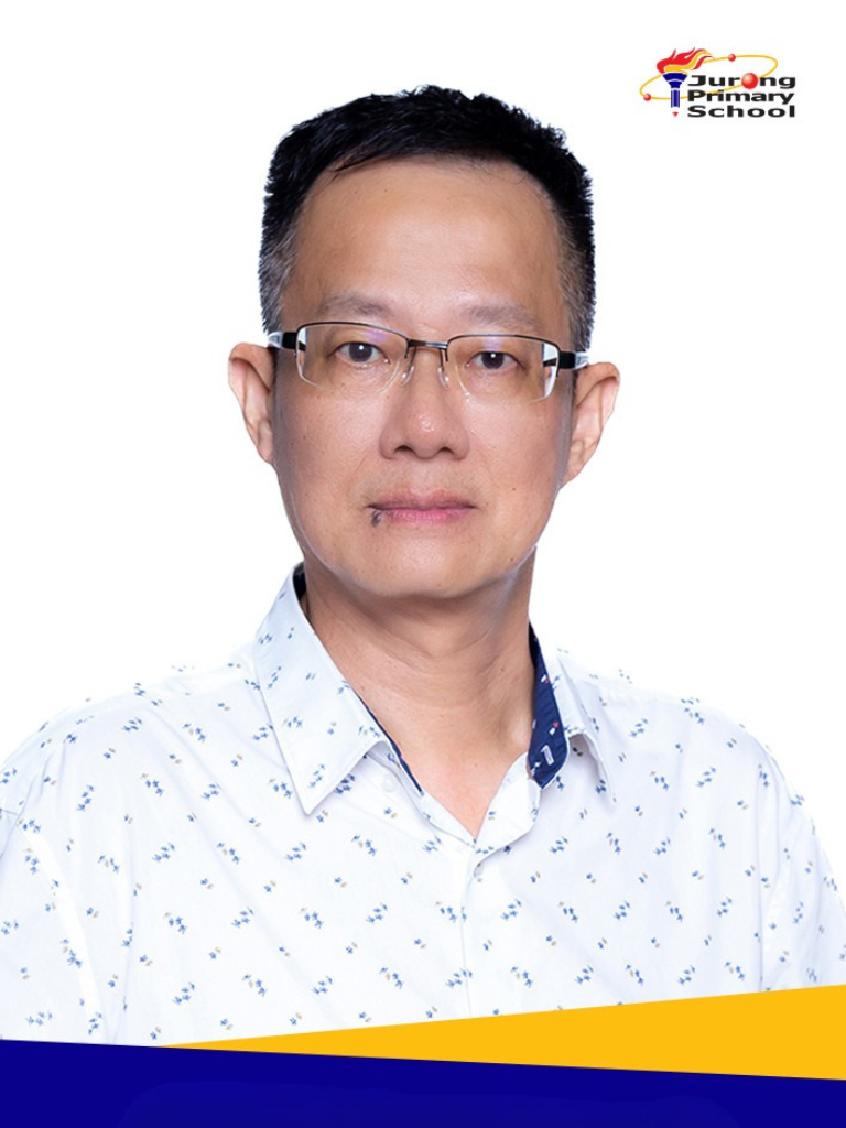  A man with short dark hair, rectangular glasses, white patterned shirt, lanyard.