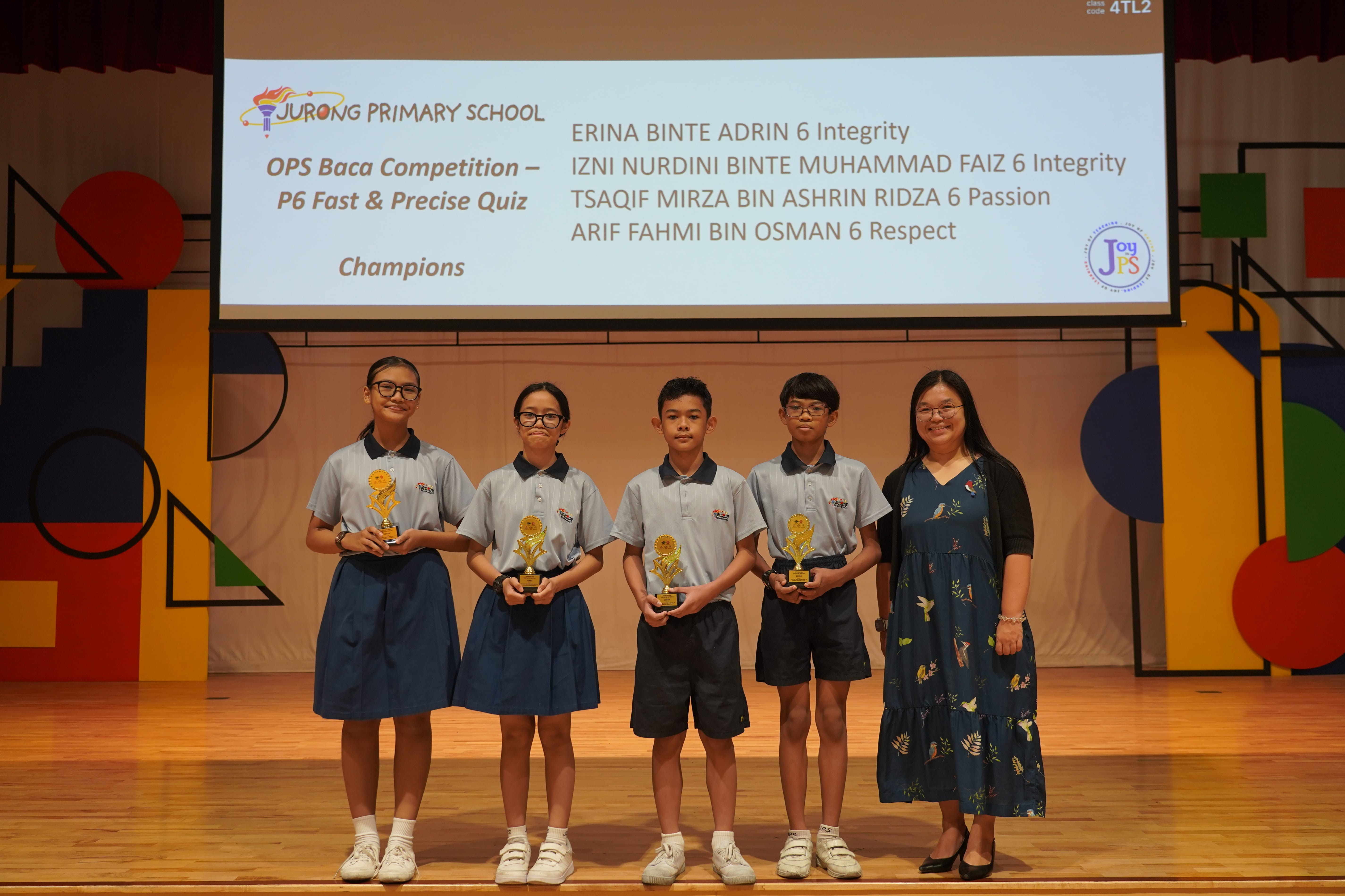 Four P6 student champions holding trophies with a Vice-Principal on stage