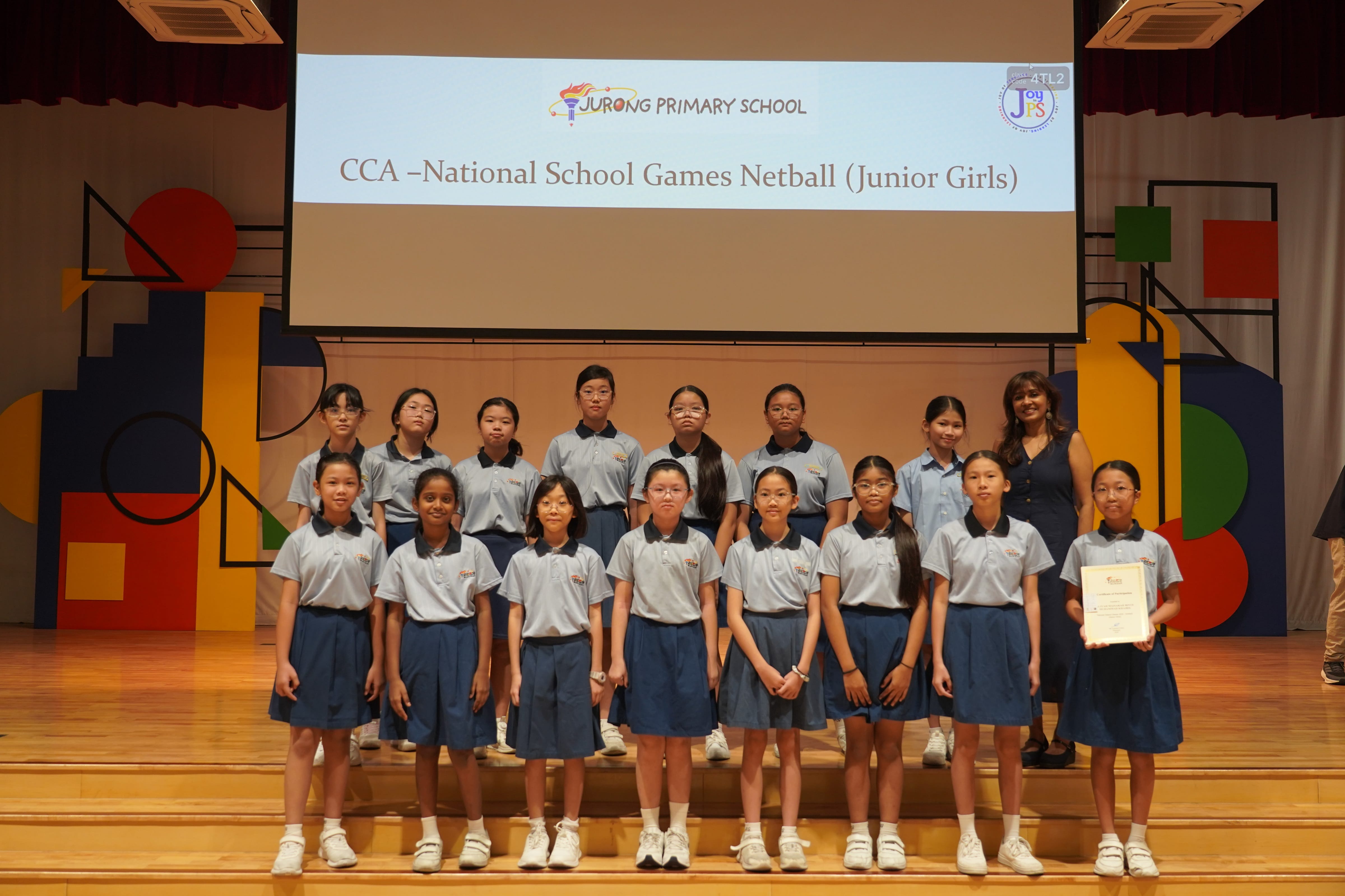 Fourteen girls with a certificate and Vice-Principal, CCA National School Games Netball Junior Girls award.