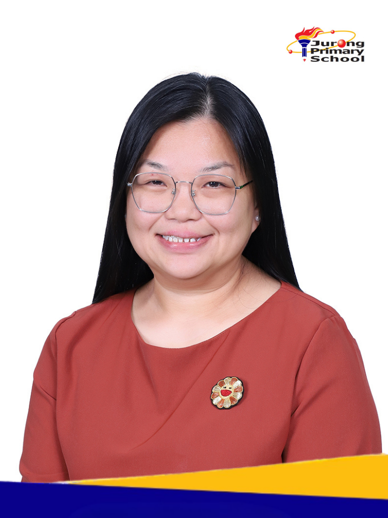 A smiling woman in glasses and a red top with a brooch.