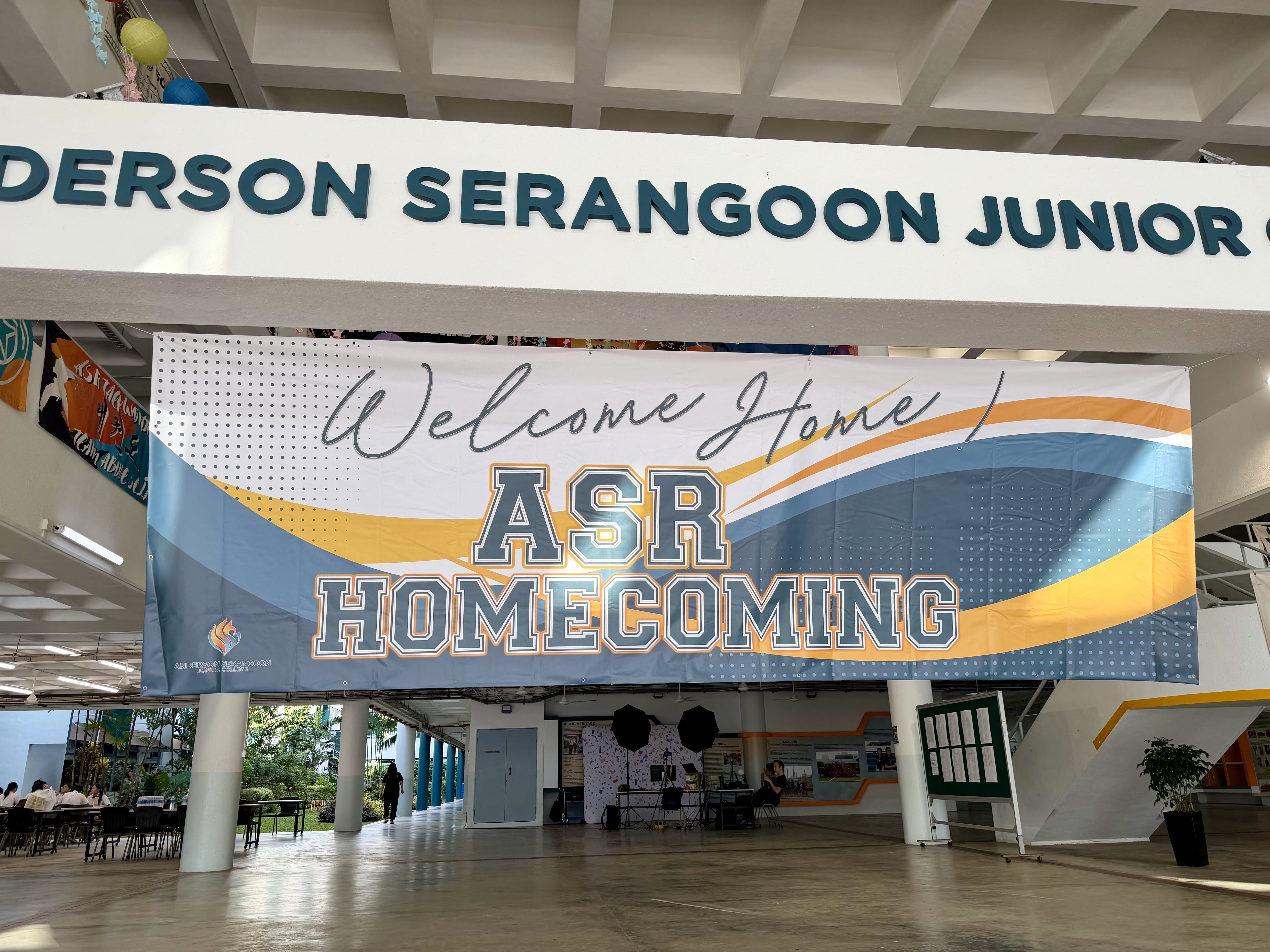 Banner with Welcome Home! ASR HOMECOMING is hung at the Foyer, under the ANDERSON SERANGOON JUNIOR COLLEGE words