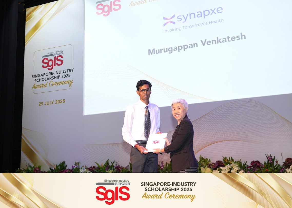 Two people on stage holding an award folder at the Singapore-Industry Scholarship 2025 ceremony on 29 July 2025.