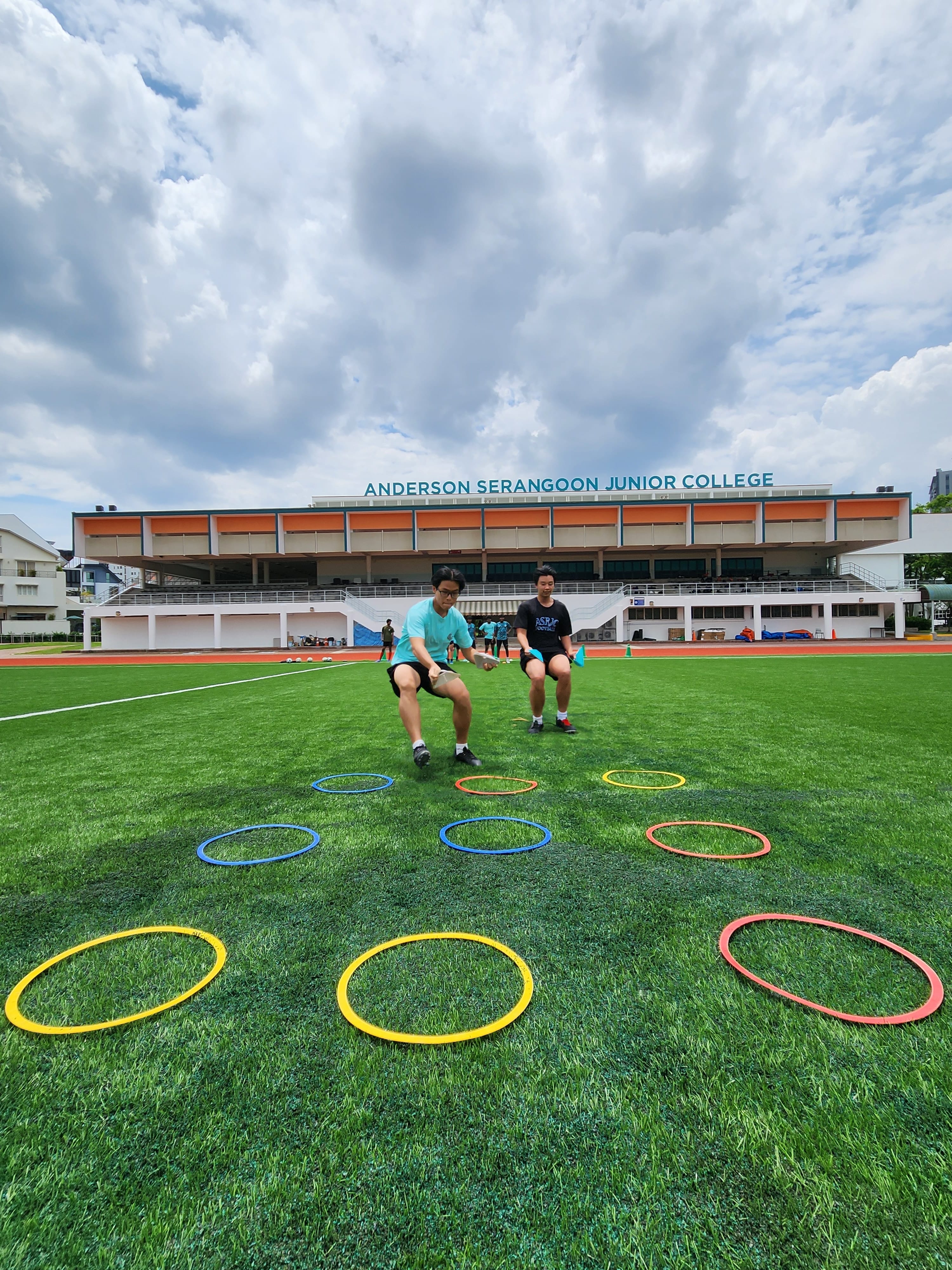 Football students playing a bonding game involving hula hoops