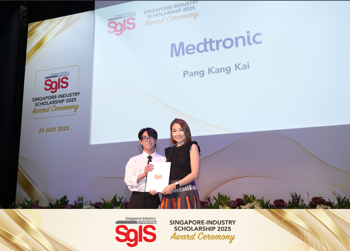 Two people hold a certificate on stage at the SgIS 2025 Award Ceremony, with a screen showing Medtronic and Pang Kang Kai.