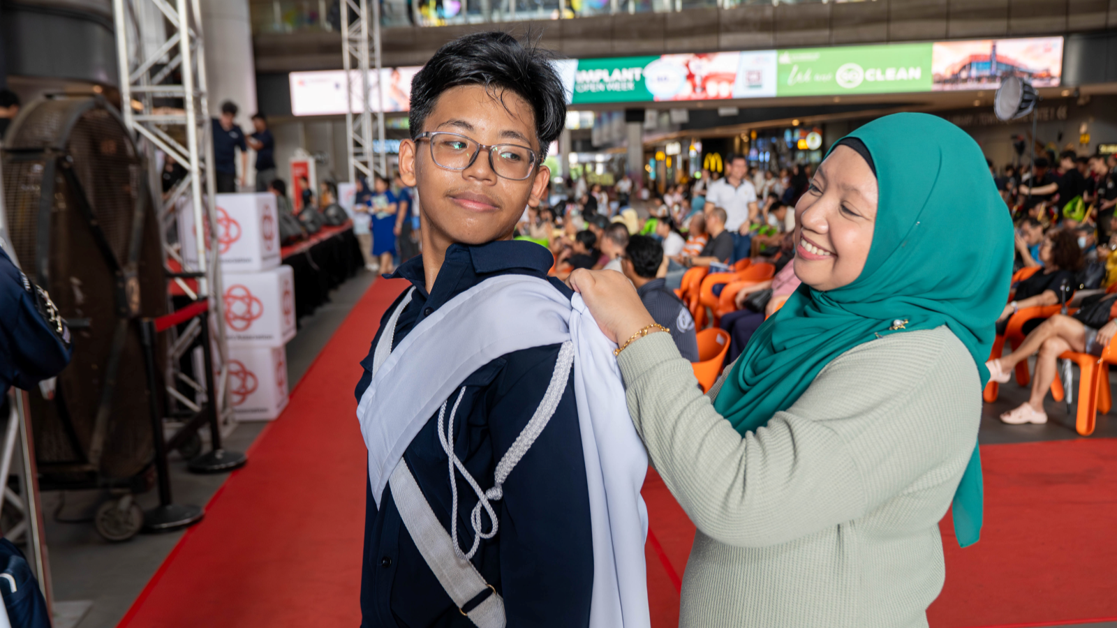 Parent tying a sash for a performer