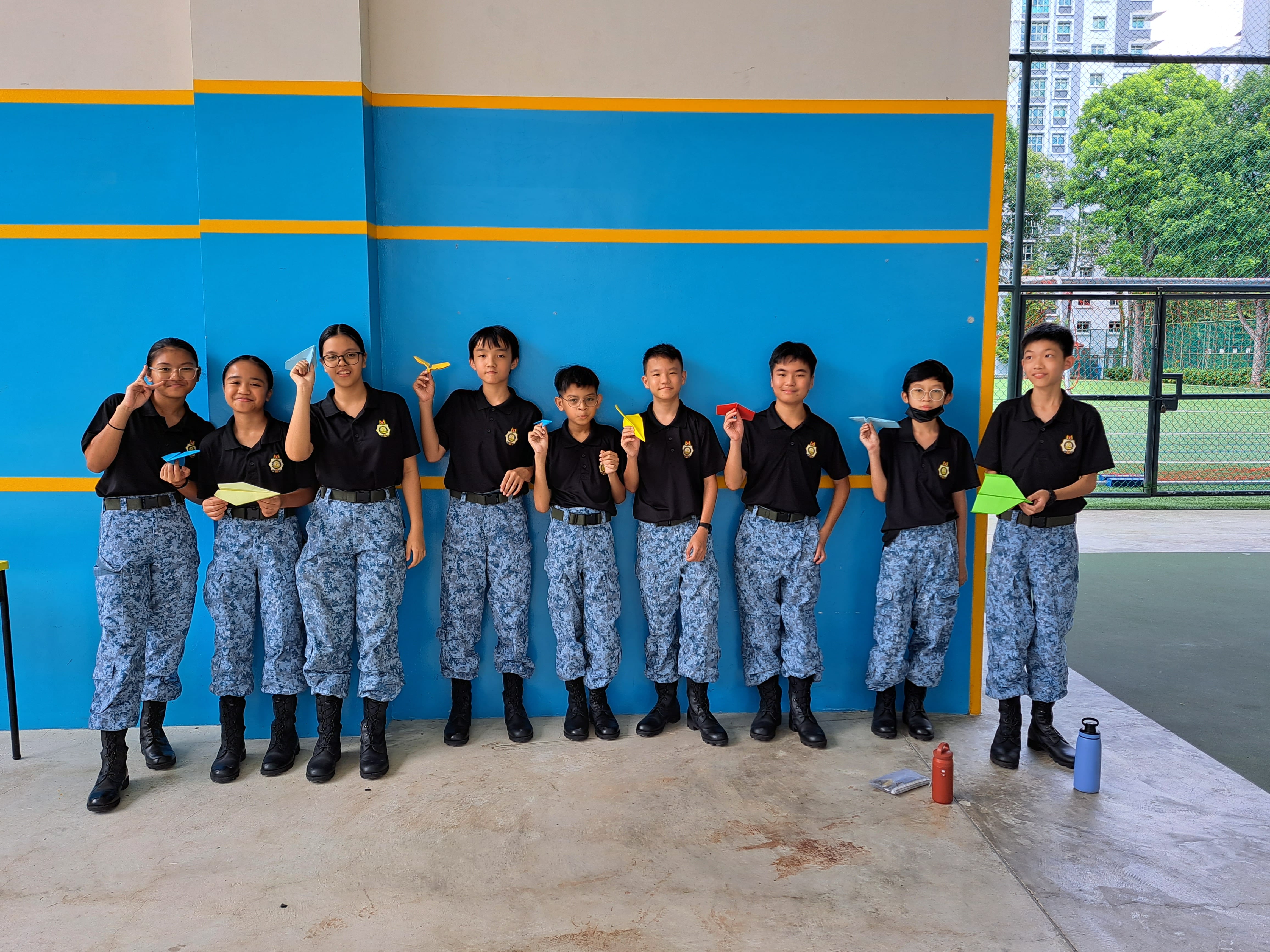 Picture shows a group of students holding paper airplanes.