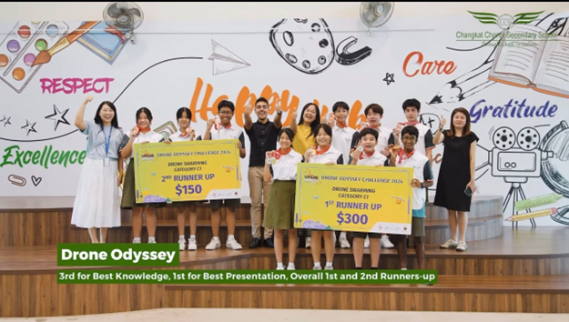 Group of students and teachers on stage holding large prize checks for 1st and 2nd Runner Up in Drone Odyssey Challenge.