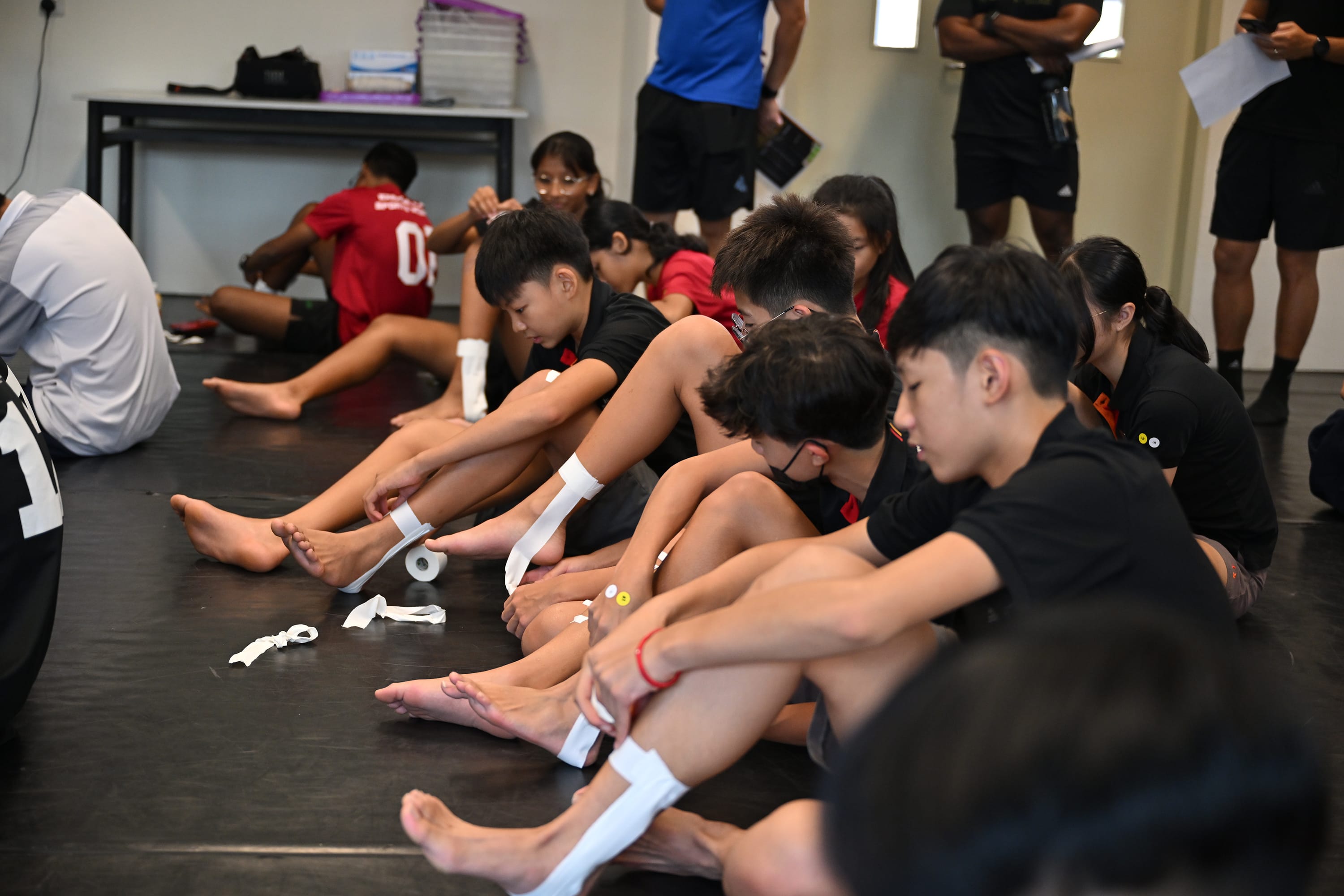 NV students taping their ankles and feet before activity.