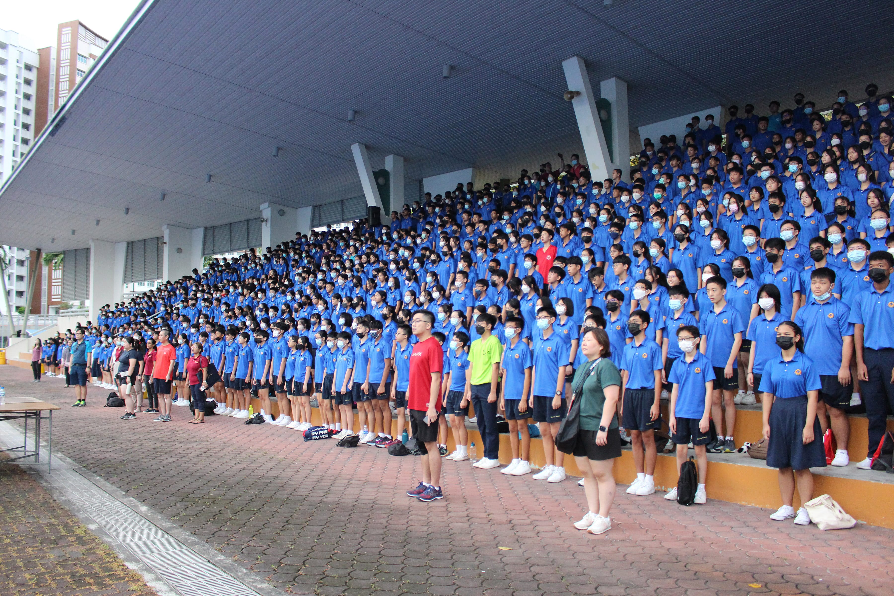 NV students stand in rows on covered stadium bleachers before the start of the Vistarian Road Run event.