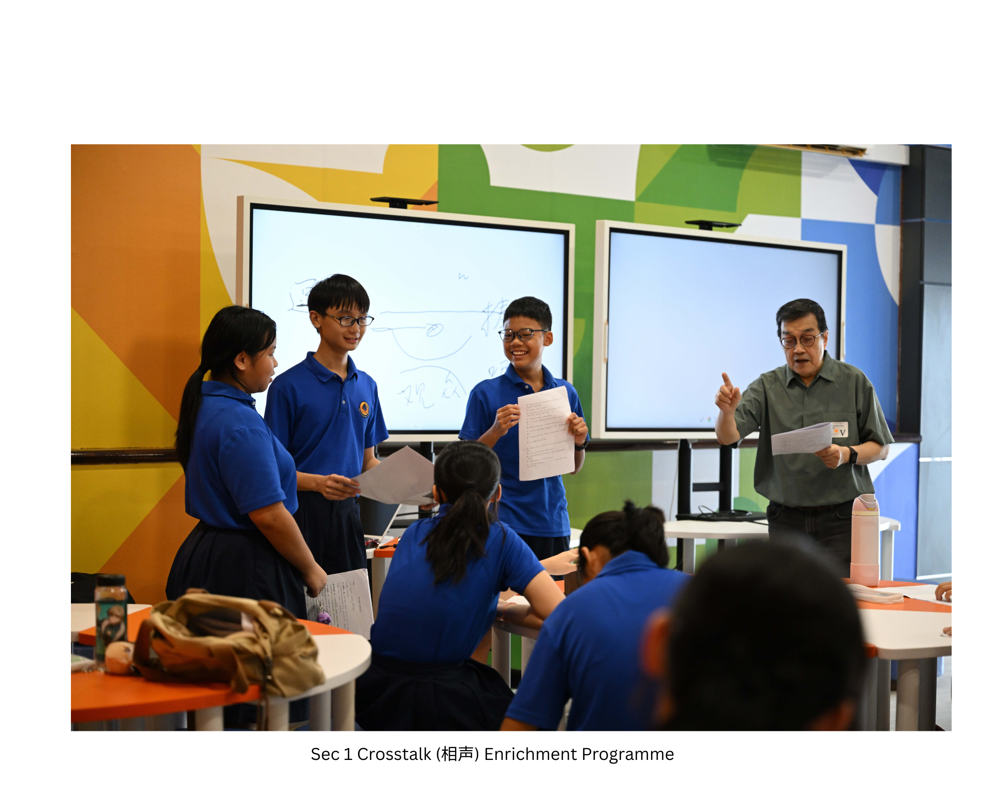 NV students presenting with a speaker in front of two large screens in the Innovation Hub.