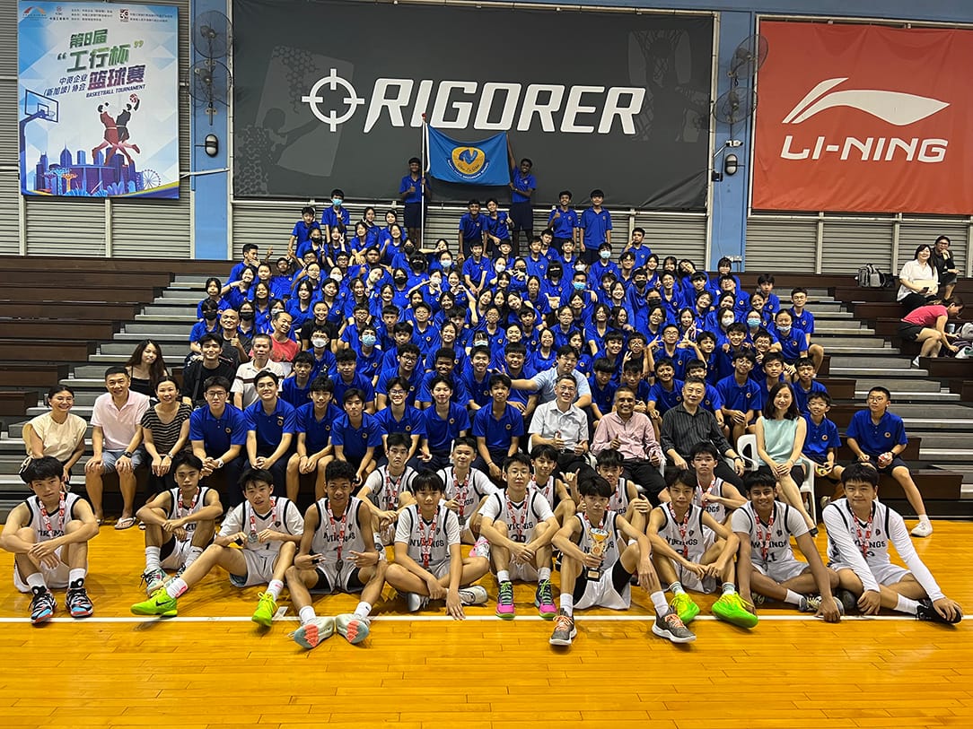 NV basketball team in blue uniforms and white jerseys posing on a basketball court.