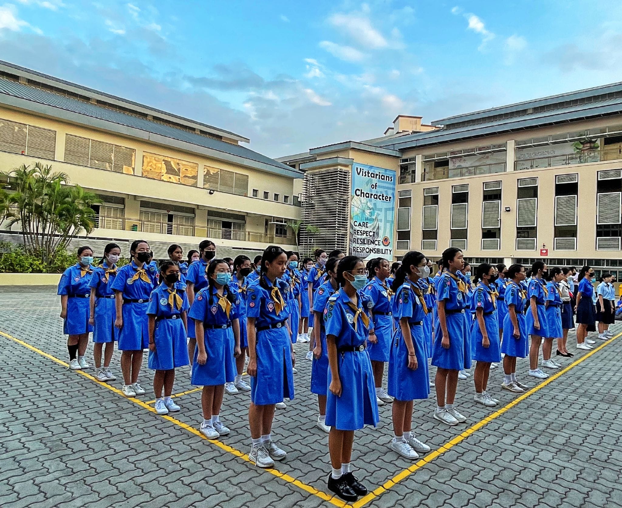 NV Girl Guides members stand in formation on the school's parade square.