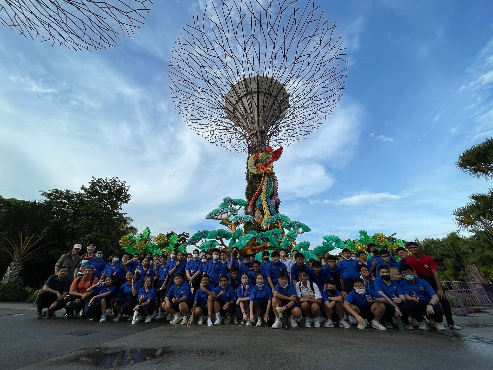 NV golfers in blue shirts pose in front of a Supertree structure at Gardens by the Bay, Singapore.
