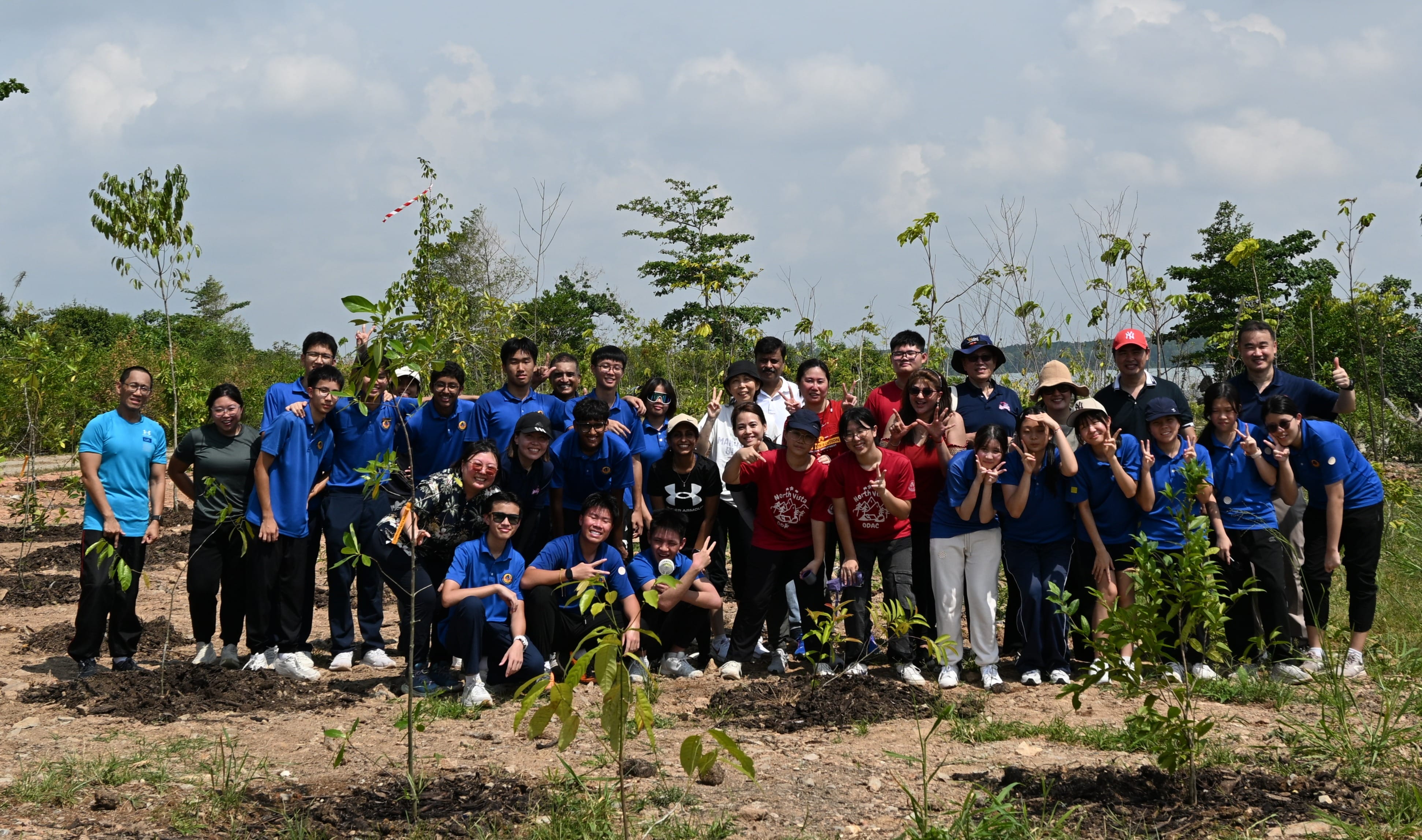 NV staff and students posing for a photo after planting trees in Pulau Ubin