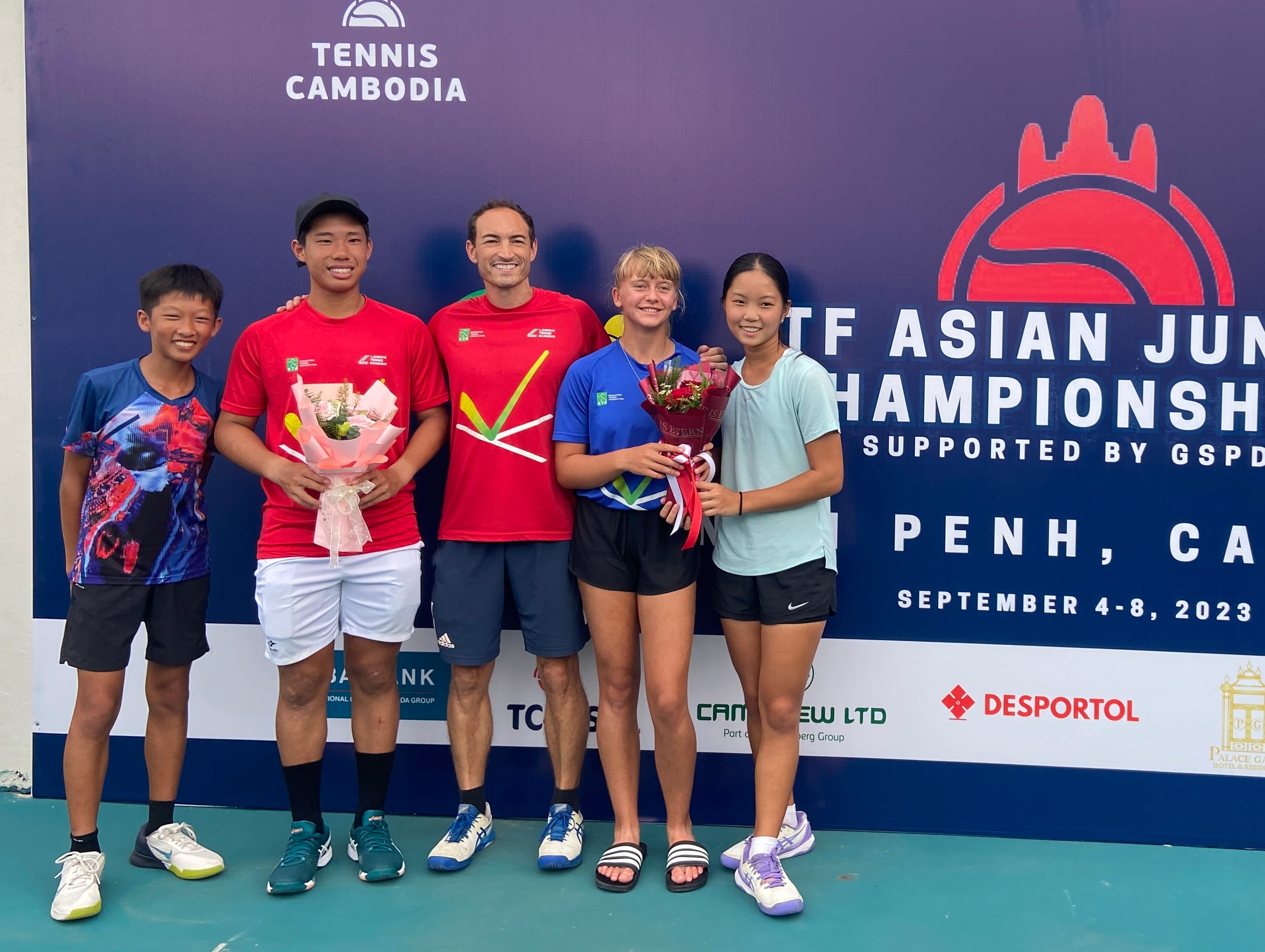 Five young tennis players pose with flower bouquets at the ITF Asian Junior Championships in Phnom Penh, September 2023.