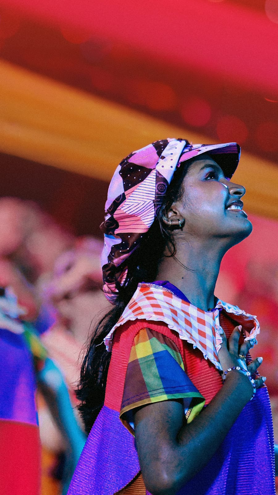 Performer in colourful costume looking up during an NDP show.
