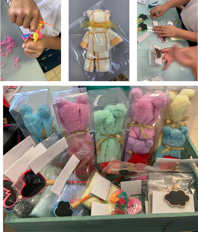 Colorful towel bears in clear boxes and handmade crafts including loom band figures and small packaged items displayed in a tray.