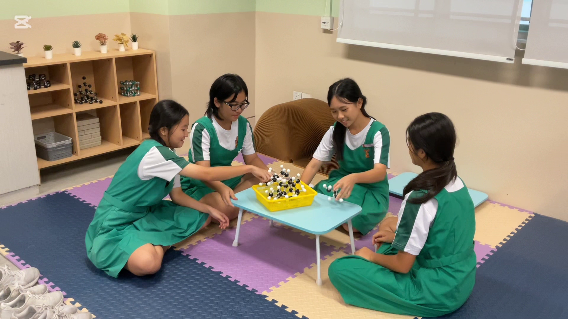 A group of students seated on the floor playing molecules