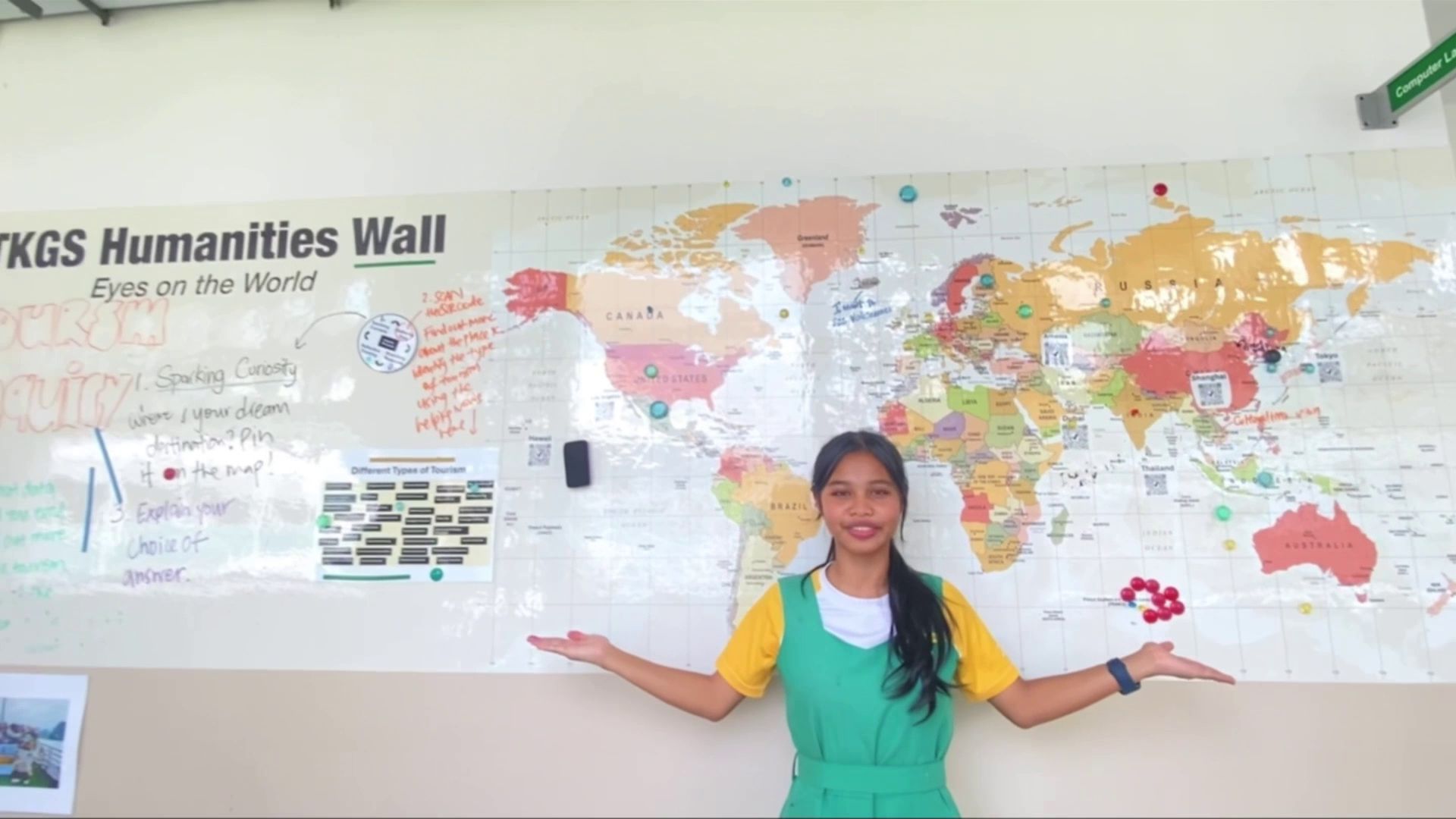 Student standing in front of a world map