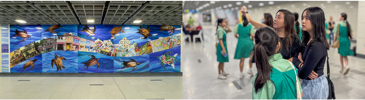 A colorful mural with sea turtles in a subway station, beside a woman pointing things out to two girls in green uniforms.