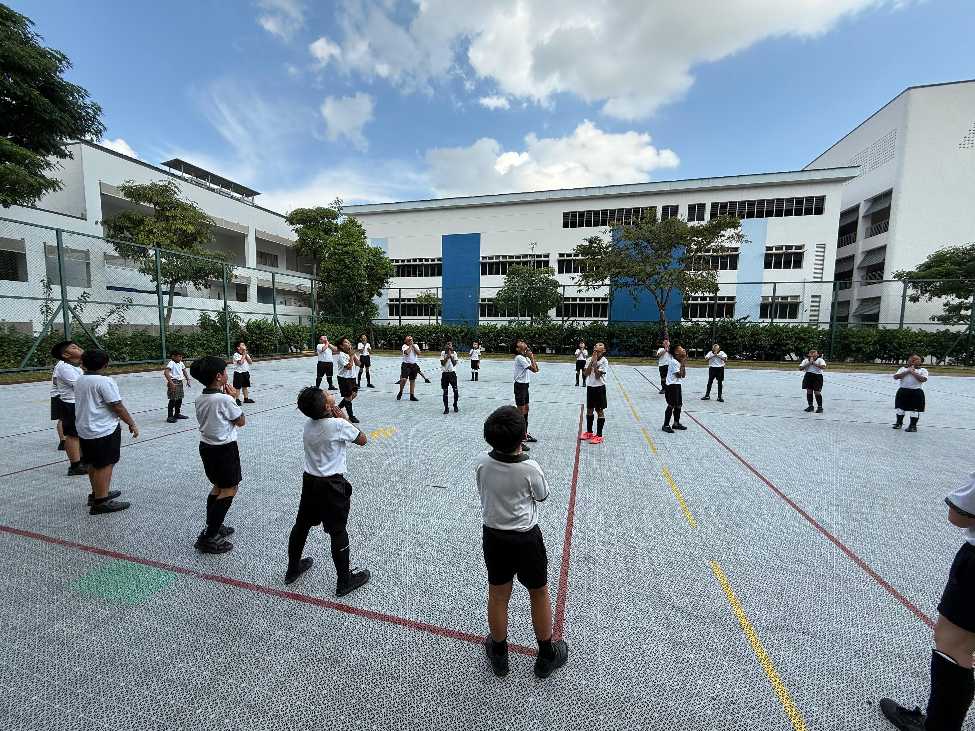 The P5 Hockey Boys leading the P3 and P4 Hockey Boys in warm-up exercises.