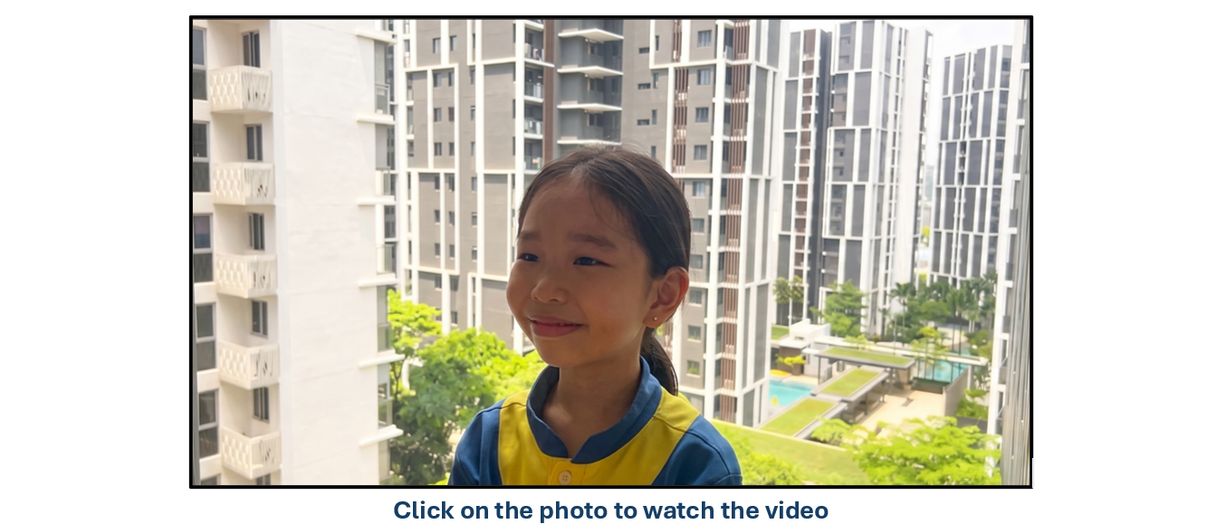 A young smiling girl in a blue and yellow uniform stands outdoors with tall residential buildings behind her.