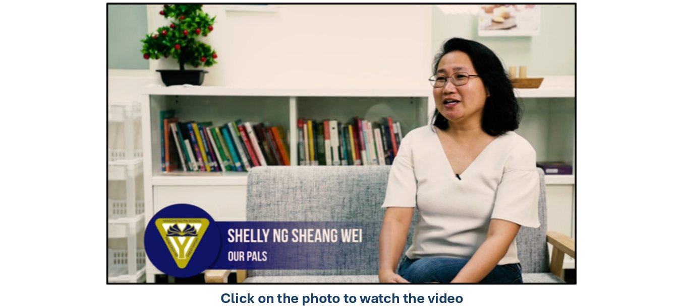 Woman with glasses sits on a sofa speaking, labeled Shelly Ng Sheang Wei, Our Pals, with bookshelves behind her.