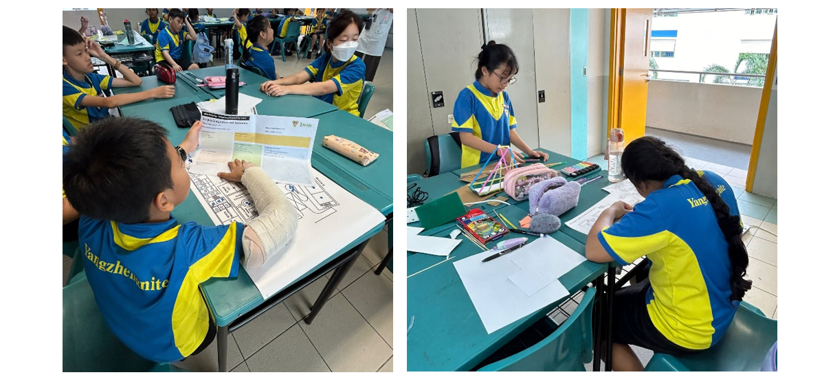 Students in blue and yellow uniforms sit at green tables working on papers and a craft project with colorful sticks.