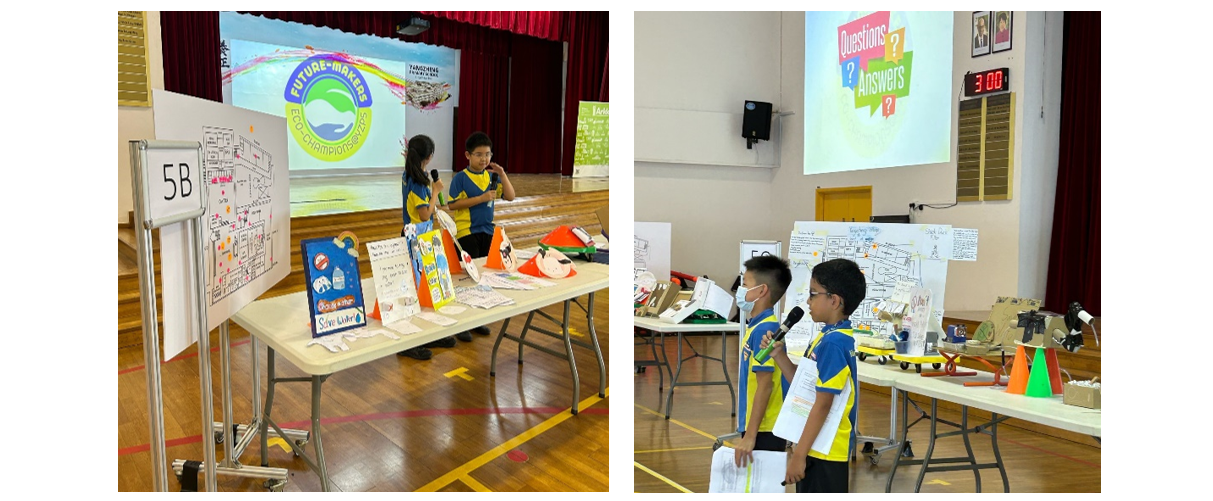 Two school children present projects at a Future-Makers Eco-Champions event, with display boards and models on tables.