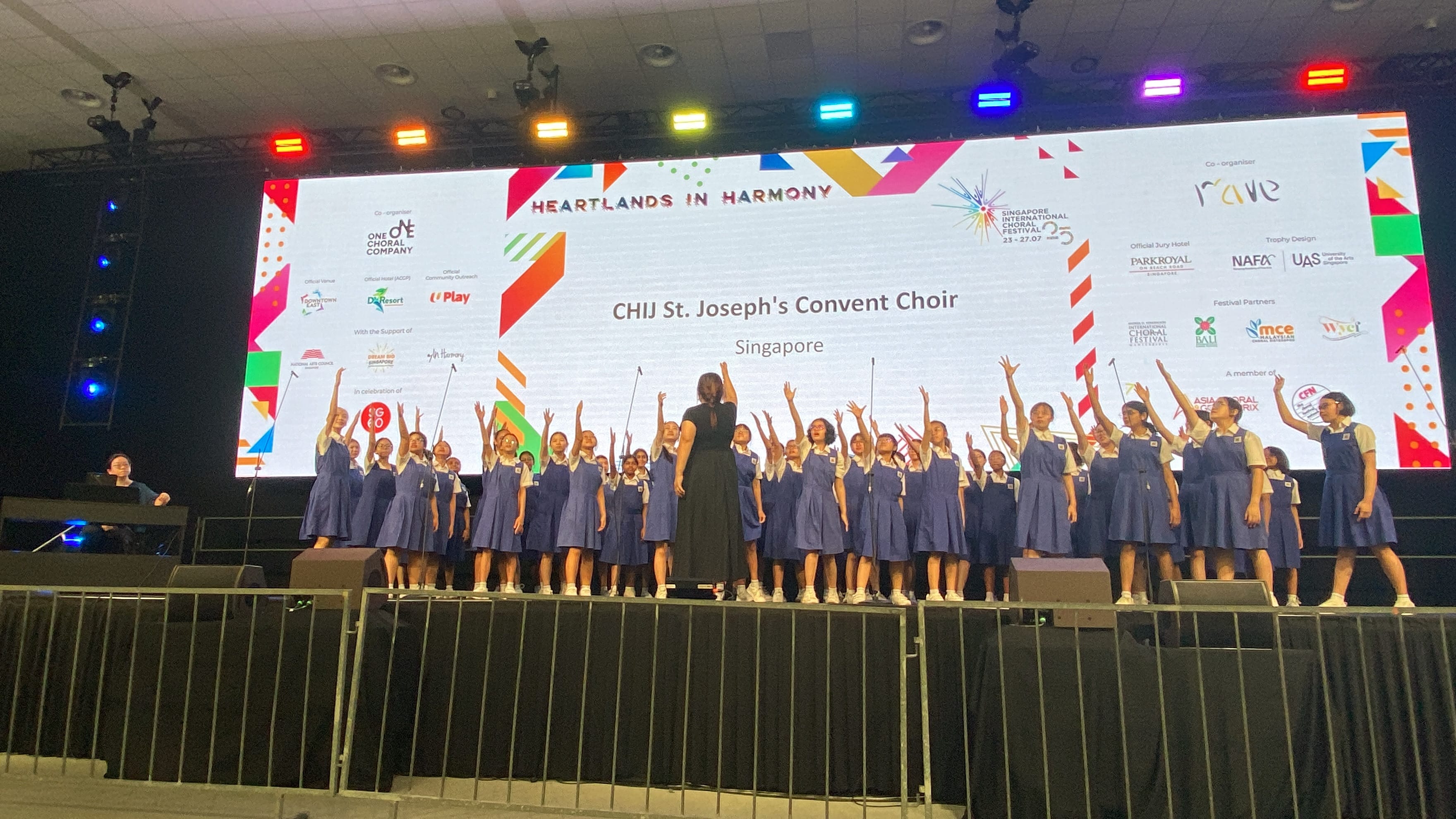 CHIJ St. Joseph's Convent Choir girls in blue uniforms perform on stage at Heartlands in Harmony festival.