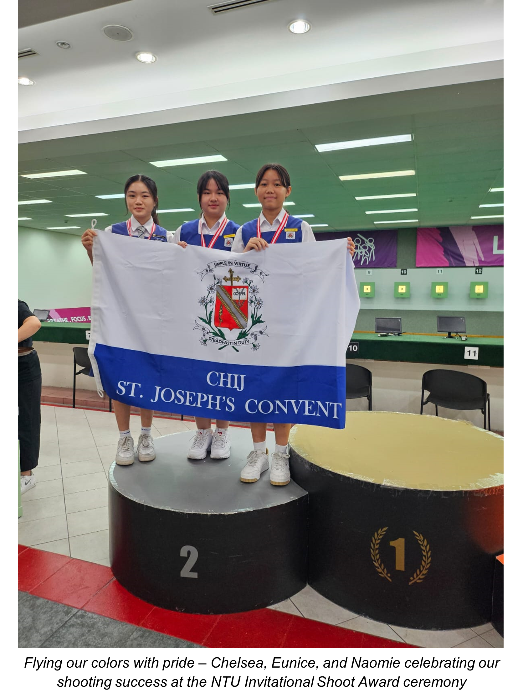 3 students holding school flag standing on podium