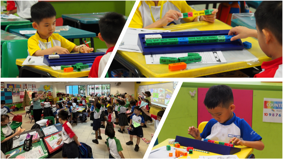 Young students in a colorful classroom using word tiles and building blocks as learning tools at yellow desks.