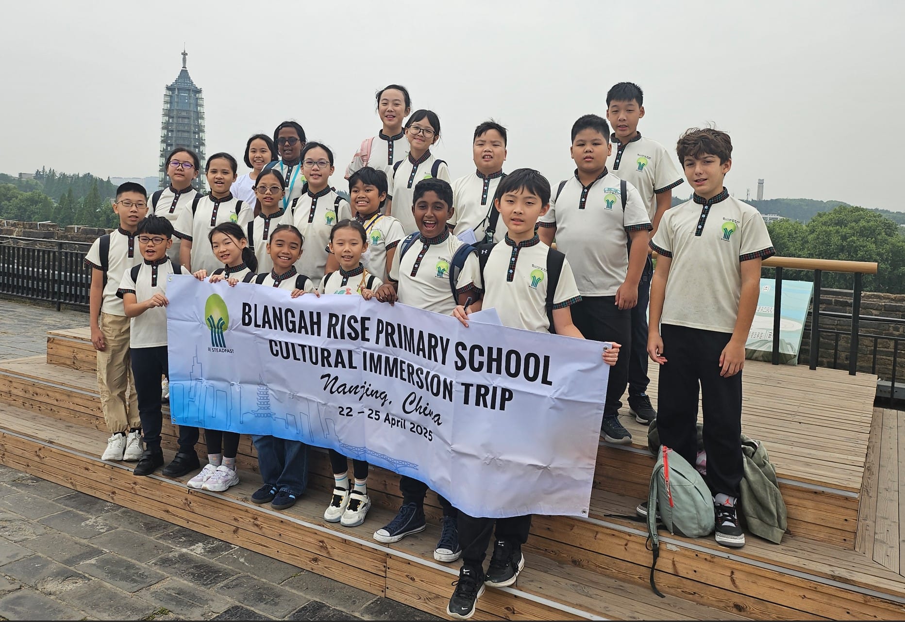 Group of school children in uniforms holding a banner reading Blangah Rise Primary School Cultural Immersion Trip, Nanjing China.