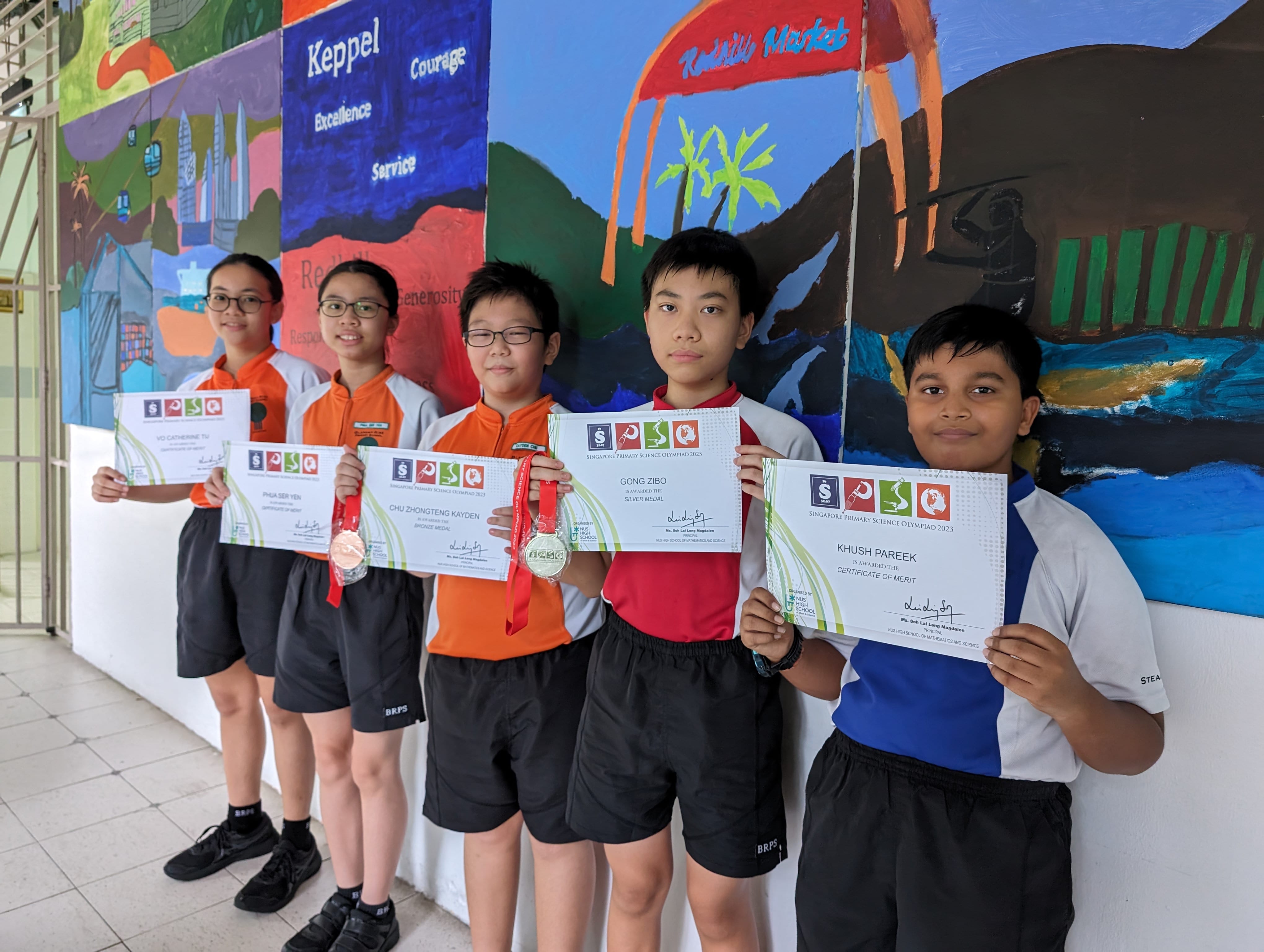 Five students hold Science Olympiad certificates and medals in front of a colorful school mural.
