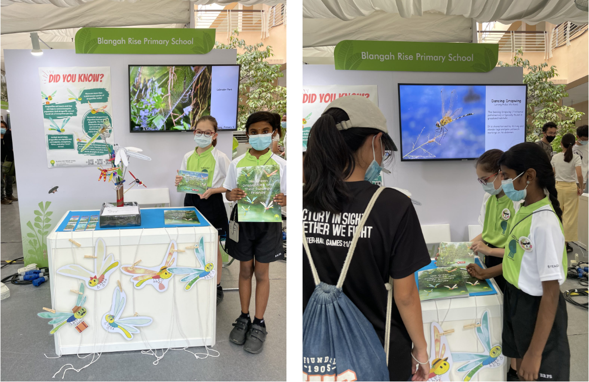 Students in green uniforms and masks present a dragonfly-themed booth for Blangah Rise Primary School.