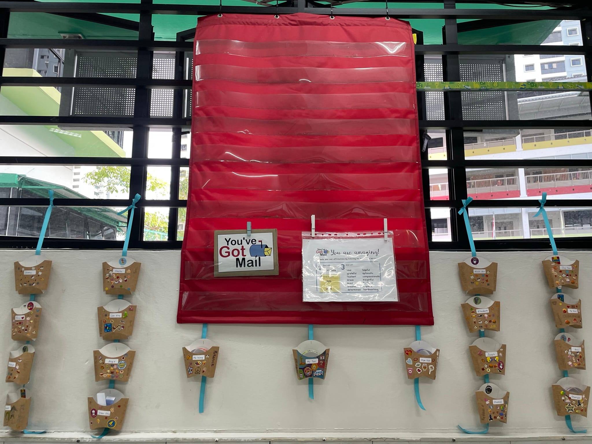 A classroom wall displays a red pocket chart labeled "You've Got Mail" with decorated cardboard mailboxes below it.