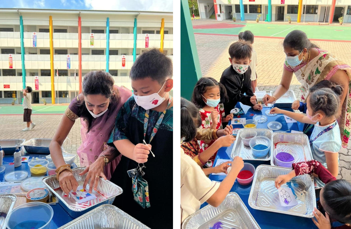 A masked teacher guides masked children in an outdoor craft activity with colored sand and trays at a school.